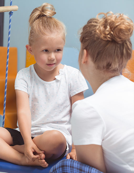 teacher explaining exercises to kid during occupational therapy